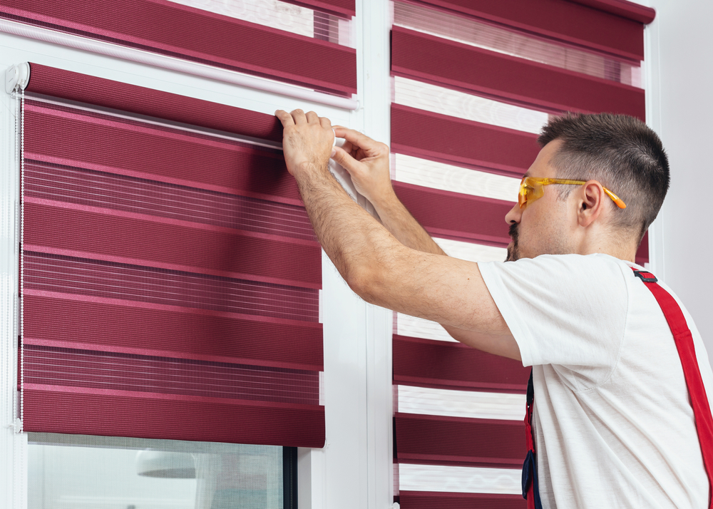 Young,Man,In,A,Uniform,Installing,New,Window,Blinds